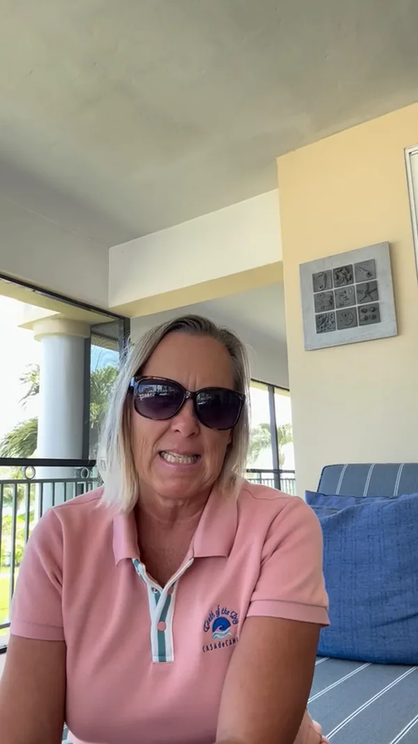 The volunteer who runs the fund, speaking to camera on a shaded balcony
